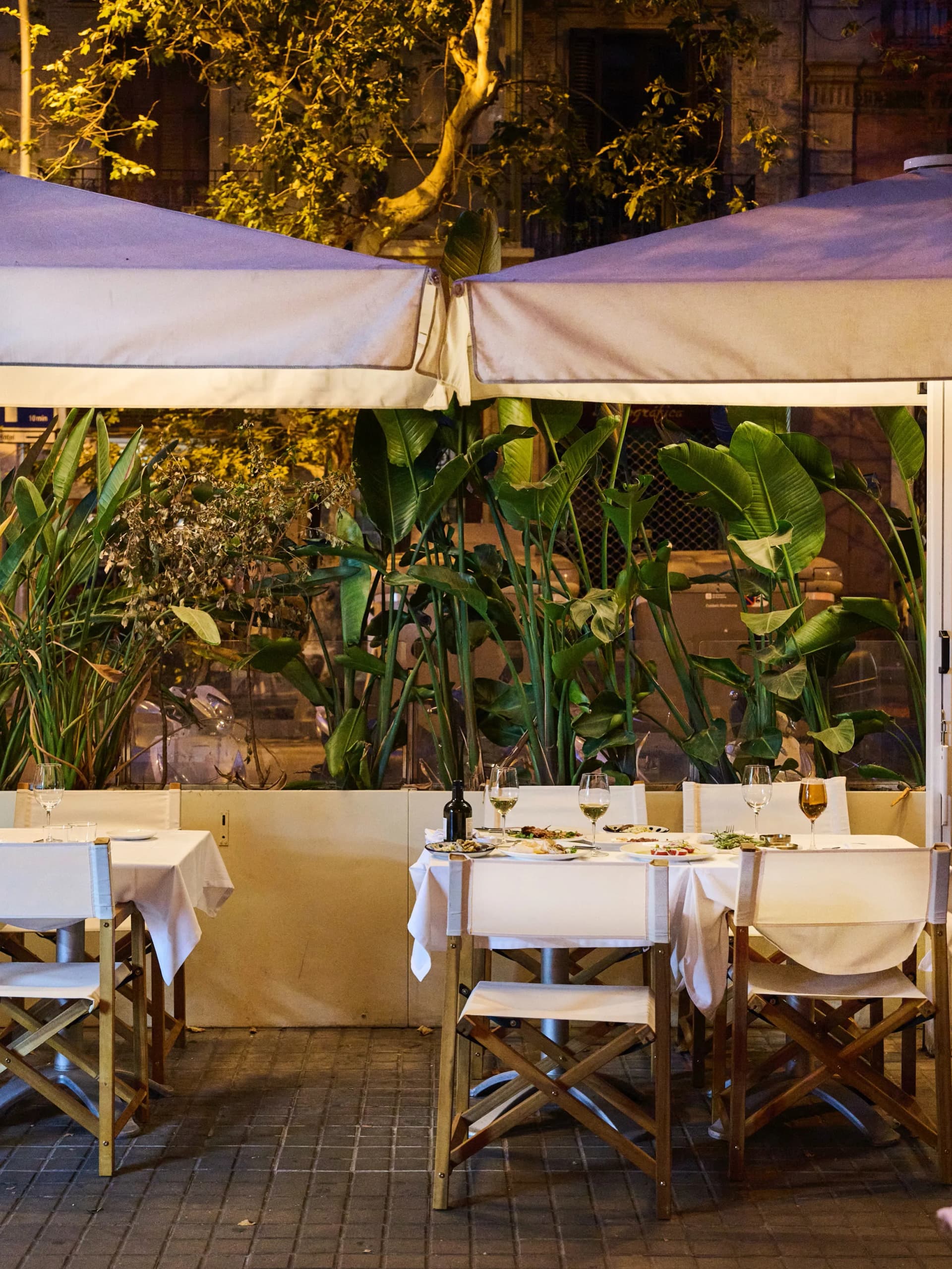 Terraza exterior de Restaurante Igueldo en Barcelona de noche, mesas con mantel blanco y copas preparadas para cenar