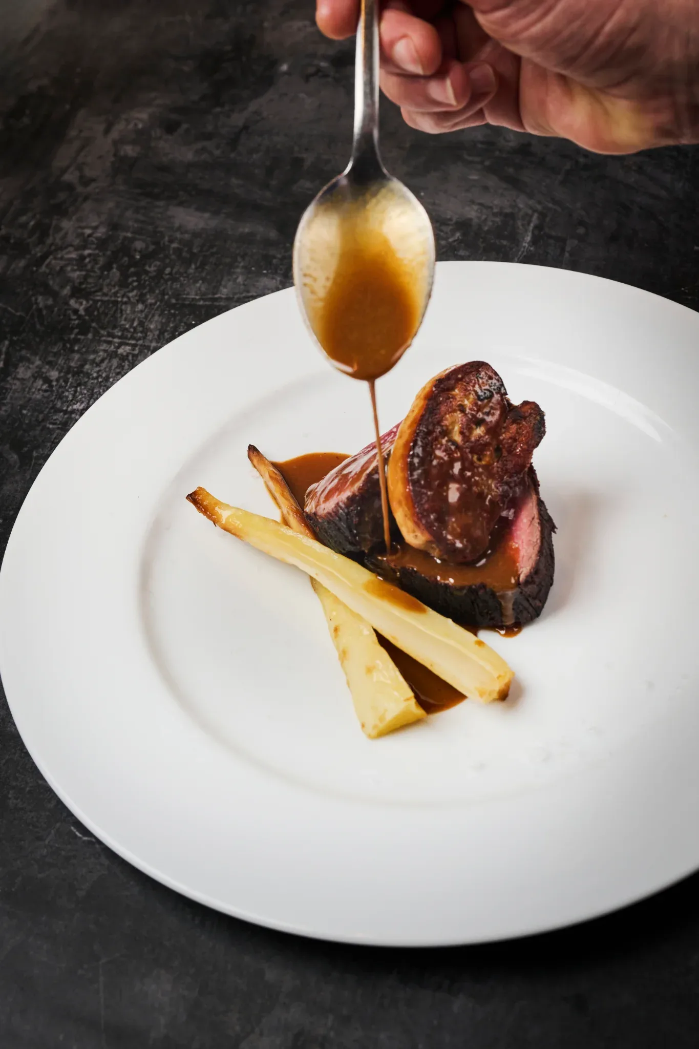 Solomillo de vaca con foie gras y salsa de oporto sobre espárragos blancos en Restaurante Igueldo, cocina mediterránea en Barcelona